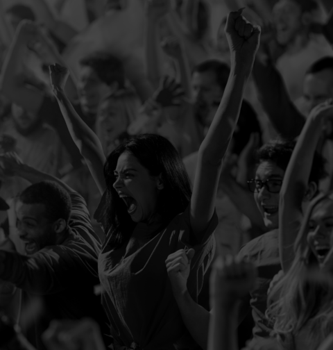 Fans of all genders and backgrounds cheer together at a game