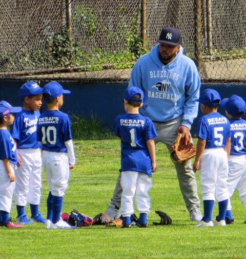 Youth baseball coach giving his team a pep talk.