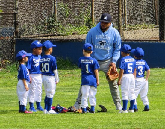Youth baseball coach giving his team a pep talk.