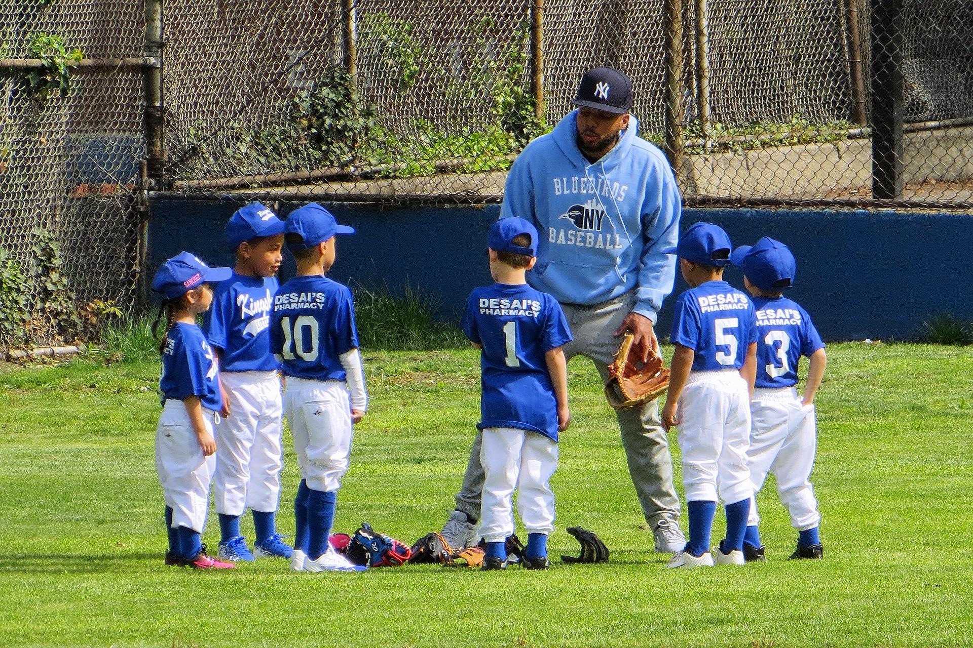 Youth baseball coach giving his team a pep talk.